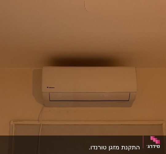 מזגן מותקן על קיר מעל חלון